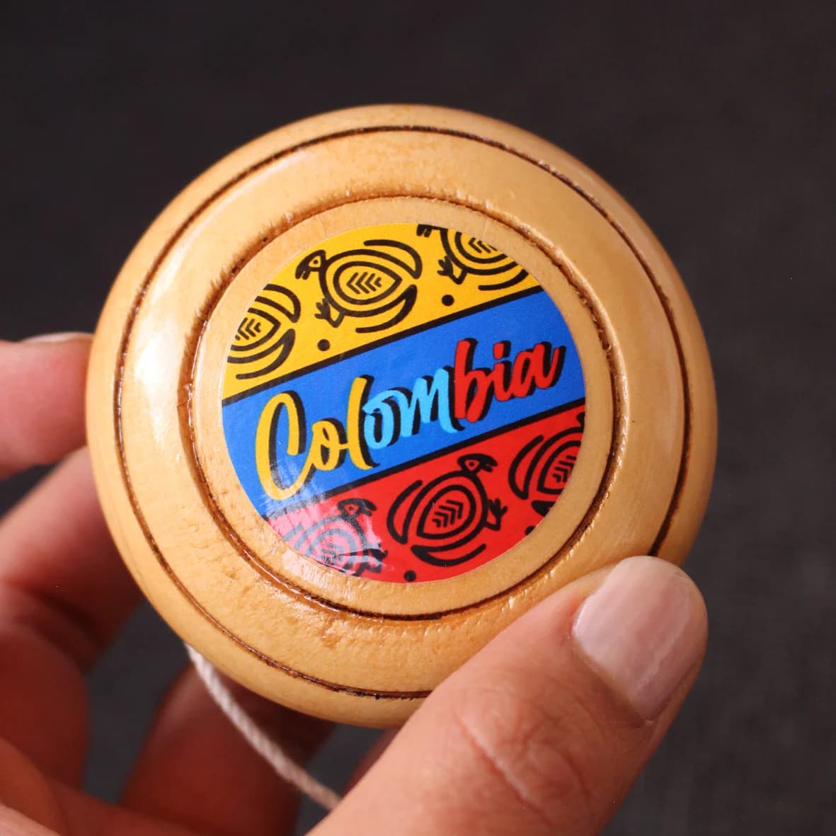 Yoyo tradicional de madera con etiqueta de Colombia.