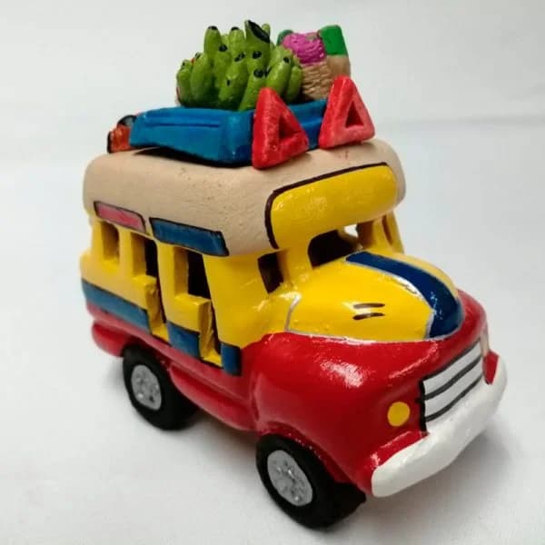 Miniatura artesanal de una chiva colombiana, hecha a mano y pintada con colores vivos.