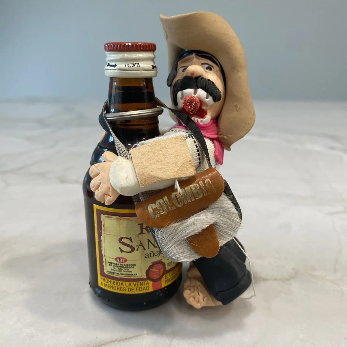 Mini botella de licor colombiana con figura artesanal