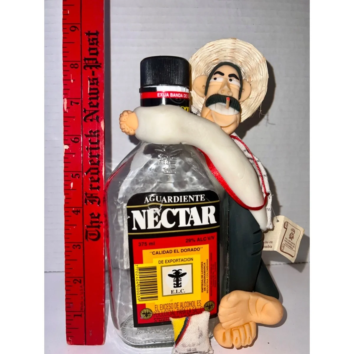 Figura artesanal colombiana de hombre paisa abrazando botella de licor